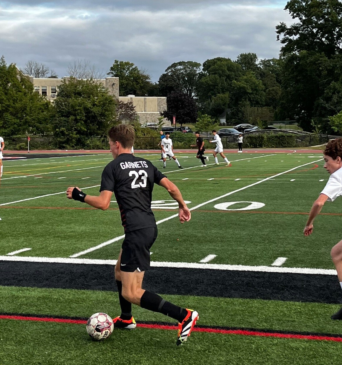 (PHOTO: Sophomore Lex Cox dribbles along the sideline for Rye Boys Varsity Soccer in their win over Irvington on Tuesday. Credit: Rye Athletics.)