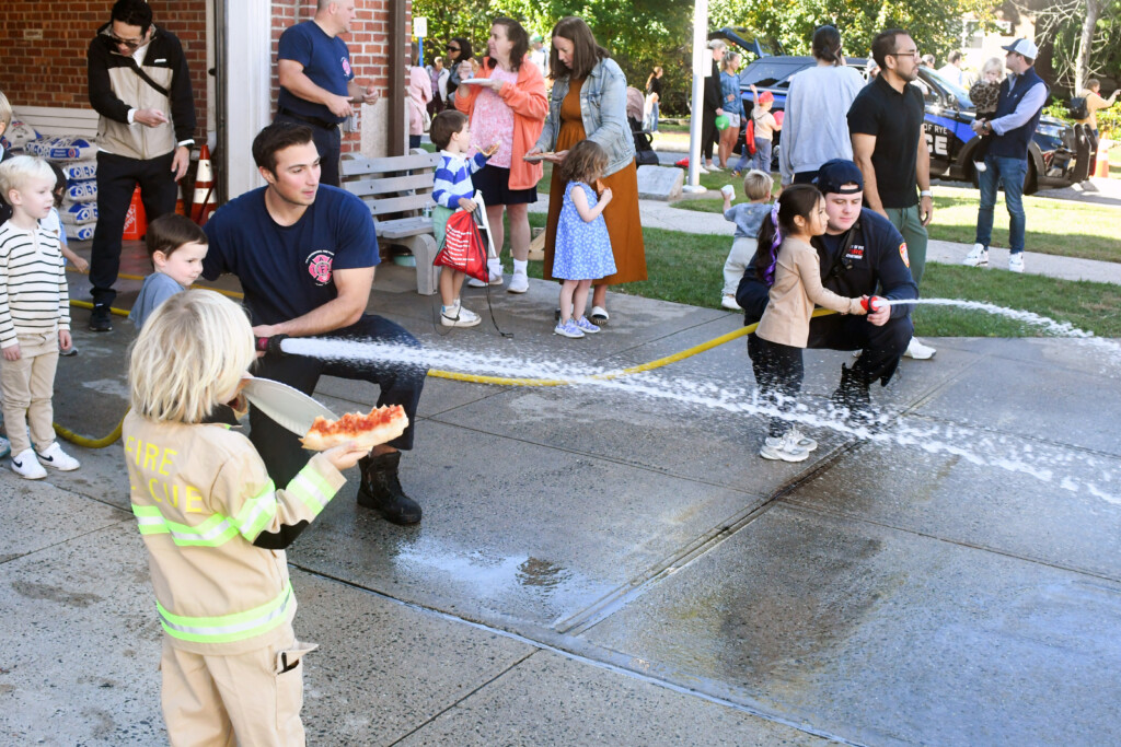 (PHOTO: Rye FD held and open house on Sunday, October 6, 2024 during fire prevention week. Firefighters Danny Archino and Thomas Junior showing the next generation how to handle a fire hose. Contributed.) 