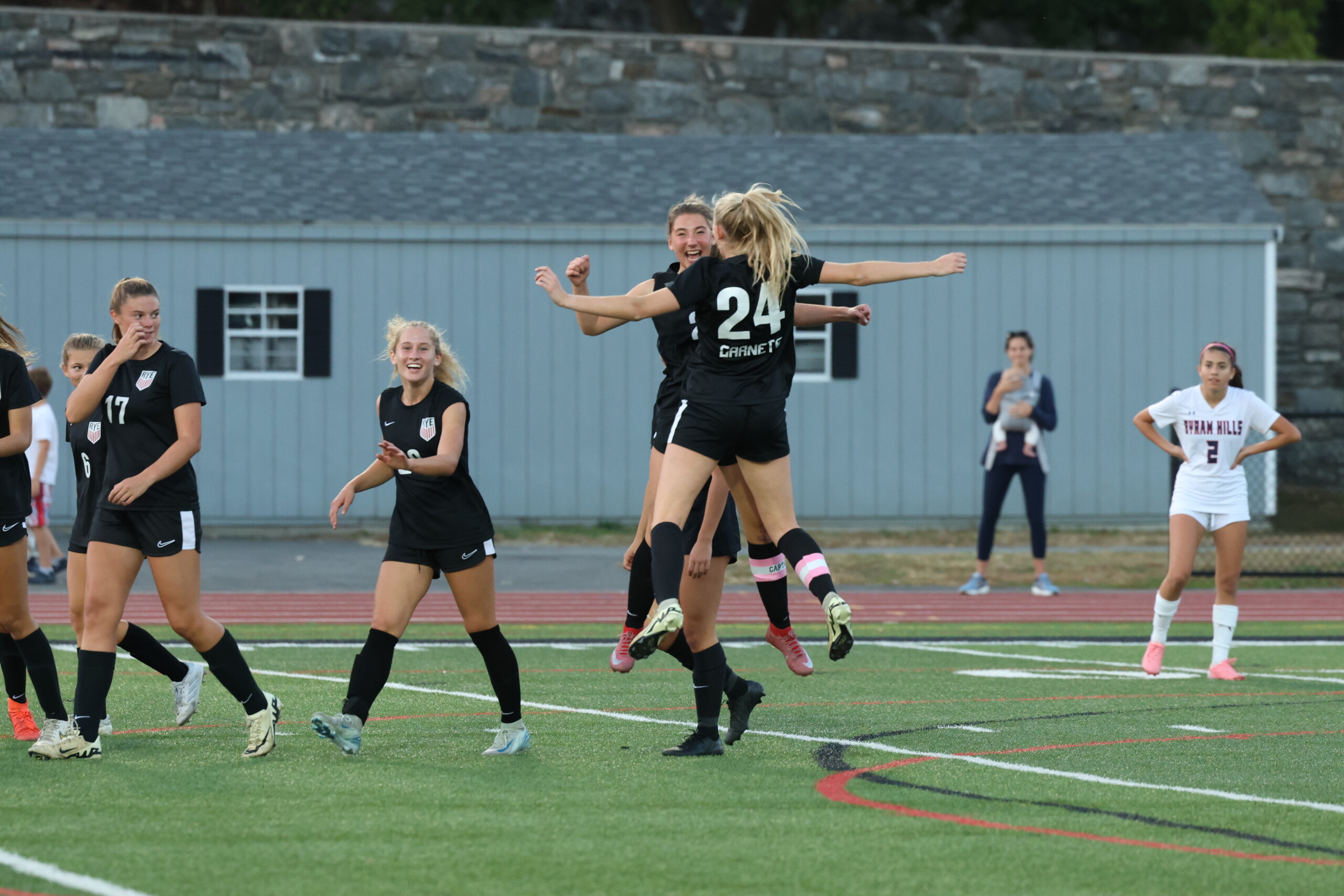 (PHOTO: Two seniors, Reese Lejuez and Mary Sack, chest bump after Lejuez's goal against Byram Hills. Credit: Alvar Lee)