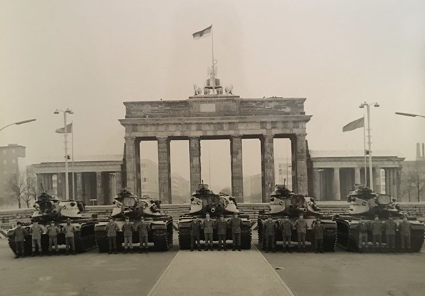 (PHOTO: US Army veteran and Milton Road resident Dennis M. McGuckian at the Brandenburg Gate, Berlin with M60A1 Tanks in 1975. He is on the far left. 2nd Lieutenant with 40th Armor, Berlin Brigade.)