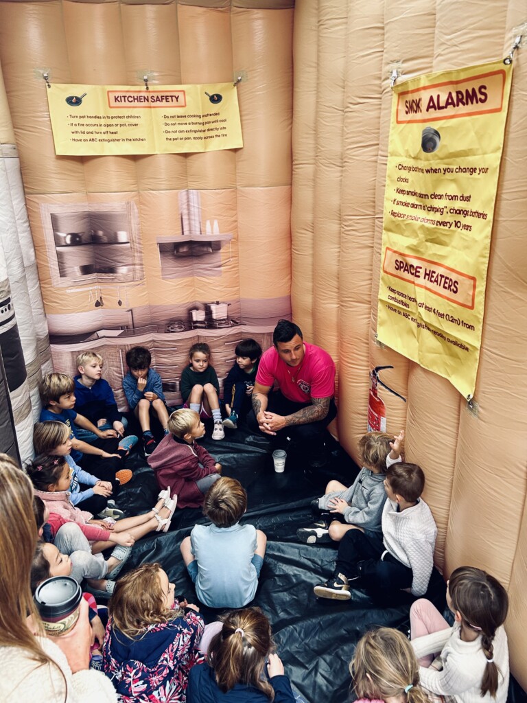 (PHOTO: Rye FD held and open house on Sunday, October 6, 2024 during fire prevention week. Firefighter Brandon Antolino inside the inflatable house delivering fire safety tips. Contributed.) 