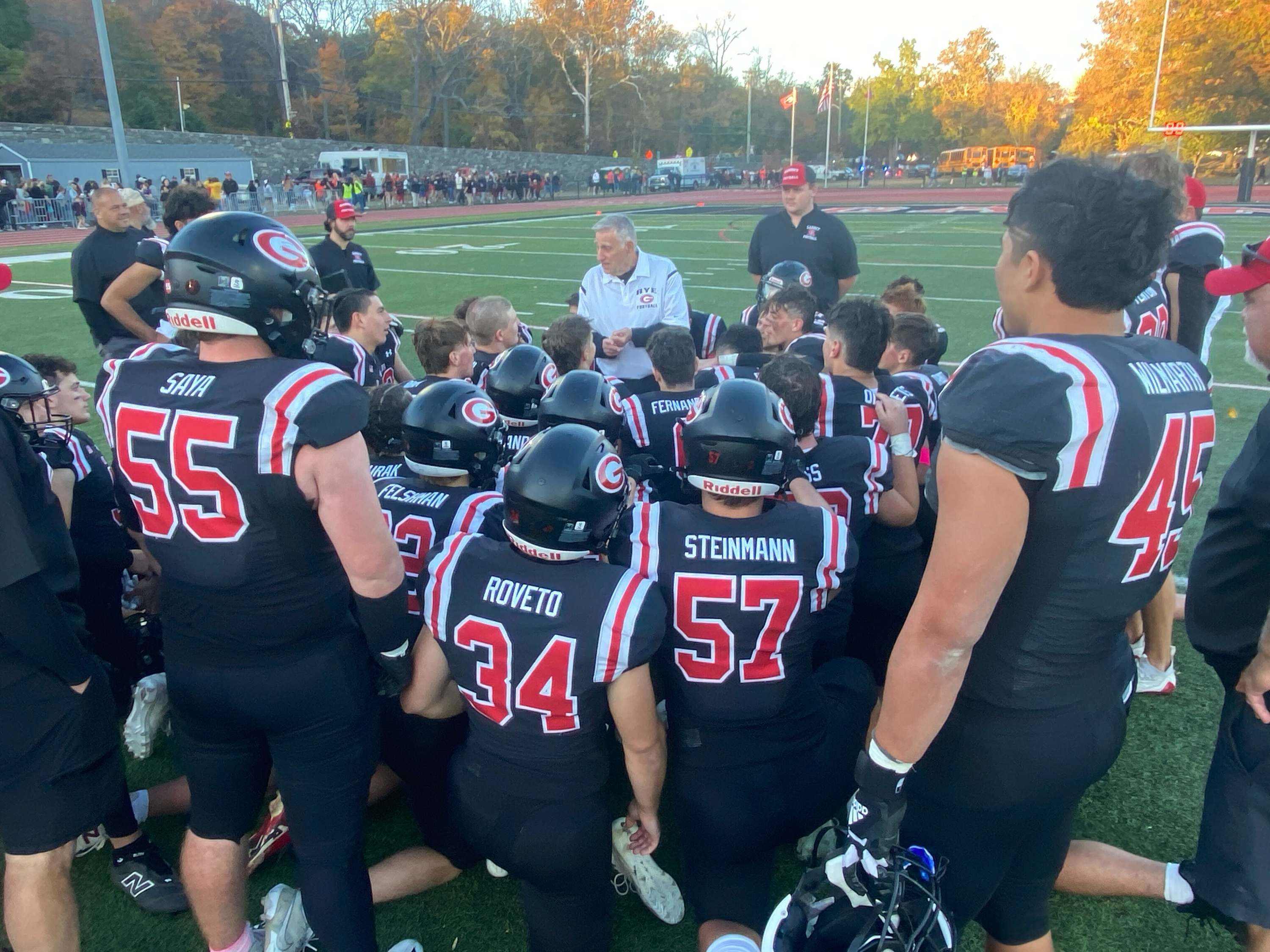 (PHOTO: The Rye Football team in their postgame huddle after defeating Harrison 24-0 in ‘The Game’ in 2024.)