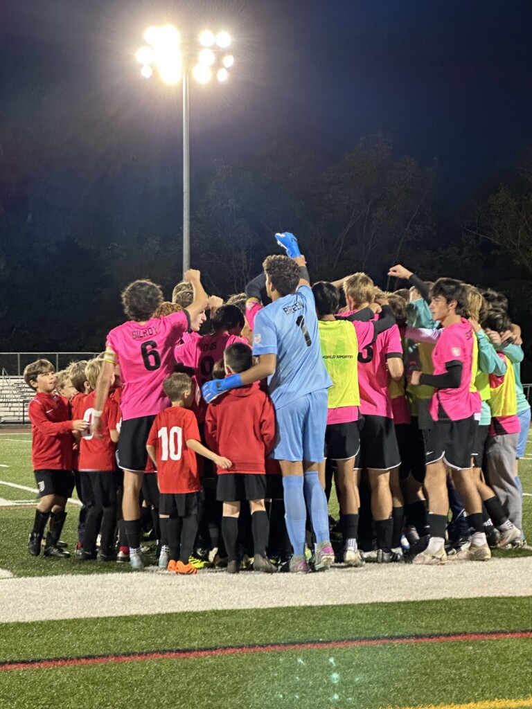 (PHOTO: Rye Youth Soccer players joined the Rye Boys Varsity Soccer team in their senior night pregame huddle. Credit: Donna Zion.)