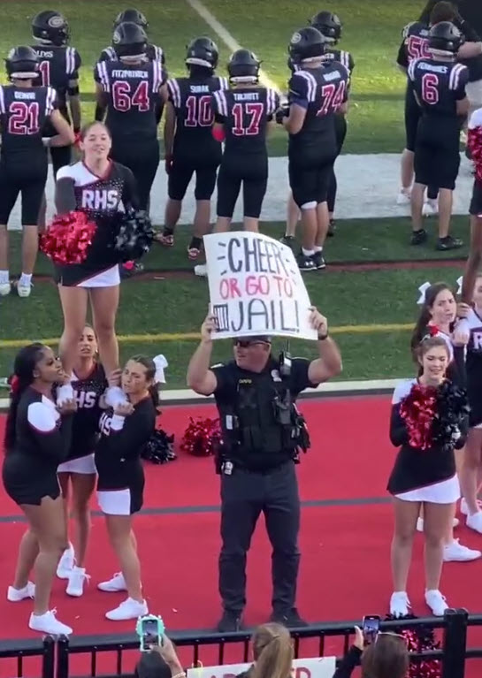 (PHOTO: Rye PD Detective Gabe Caputo sending a clear message with the Cheer Team during Saturday's 97th Rye - Harrison football match-up. The Garnets took the win 24 - 0.)