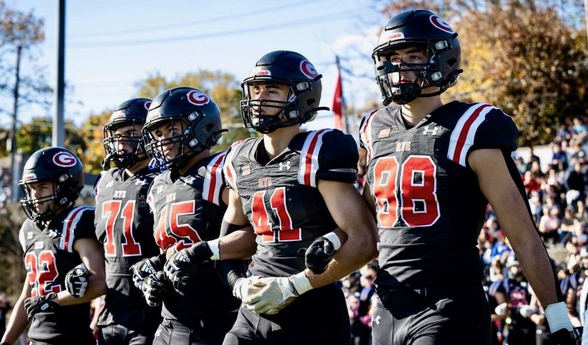 (PHOTO: Rye Football's captains join arms ahead of their Week 7 in 'The Game'. Credit: Rye Athletics)