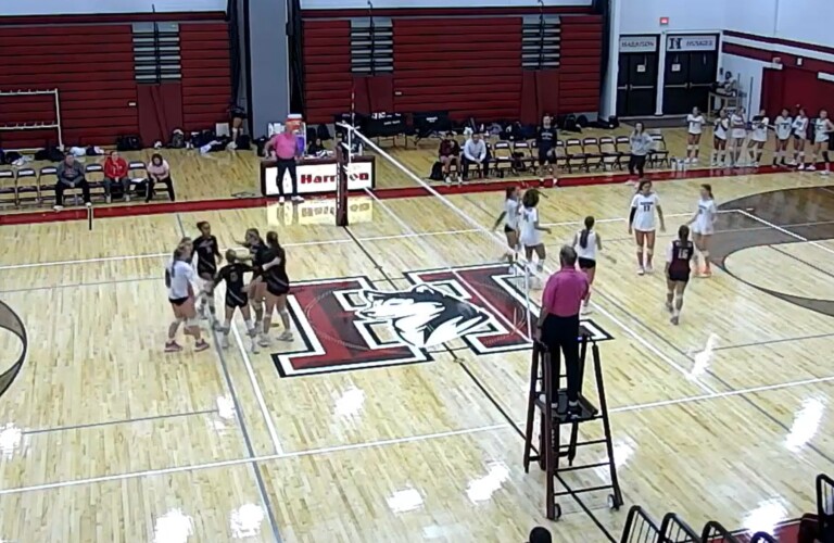 (PHOTO: Rye Varsity Volleyball huddles after winning a point in set 3 against Harrison on Tuesday evening.)