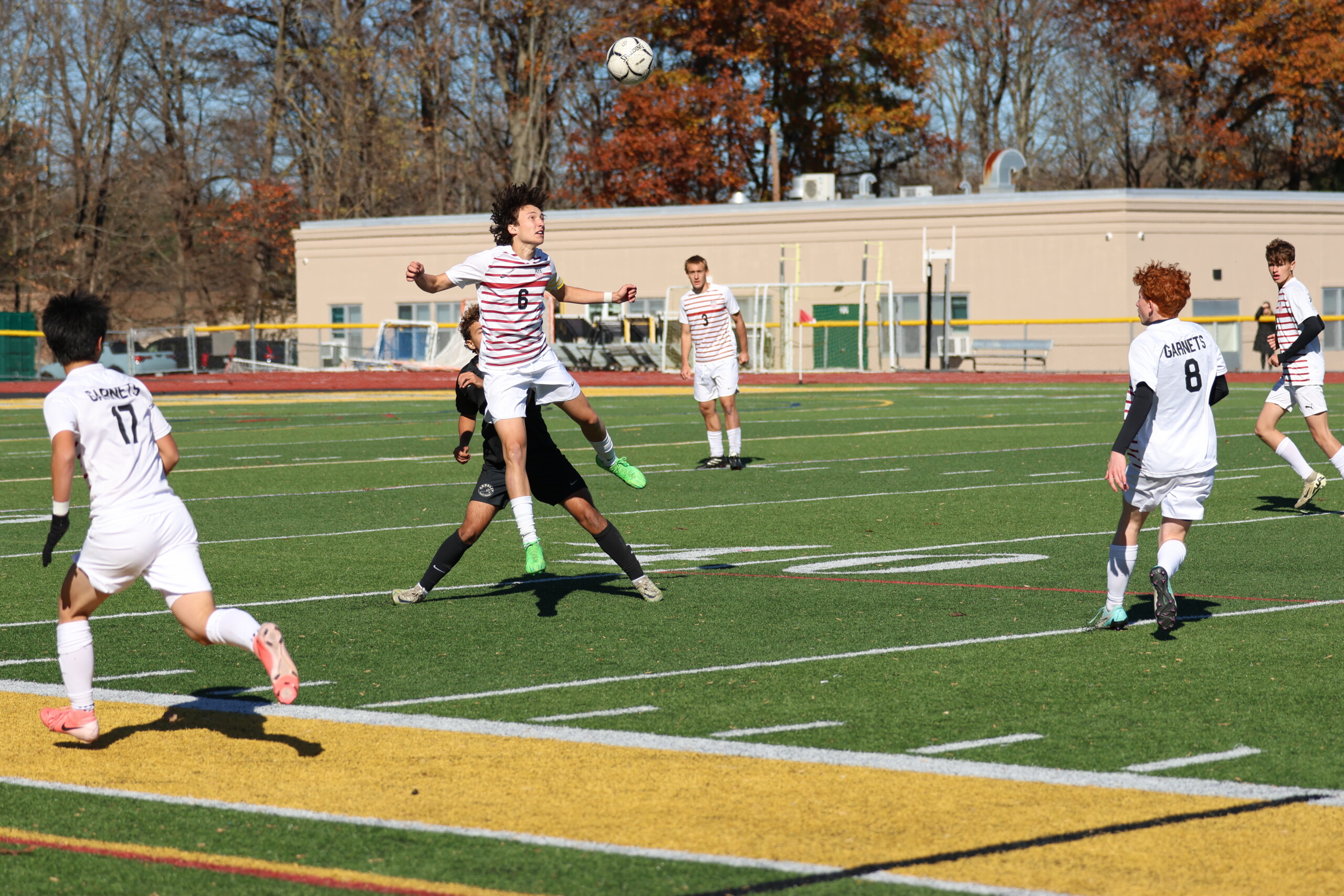 (PHOTO: Rye's Jack Gilroy wins a header against Ardsley in the Sectional Finals. Credit: Alvar Lee)