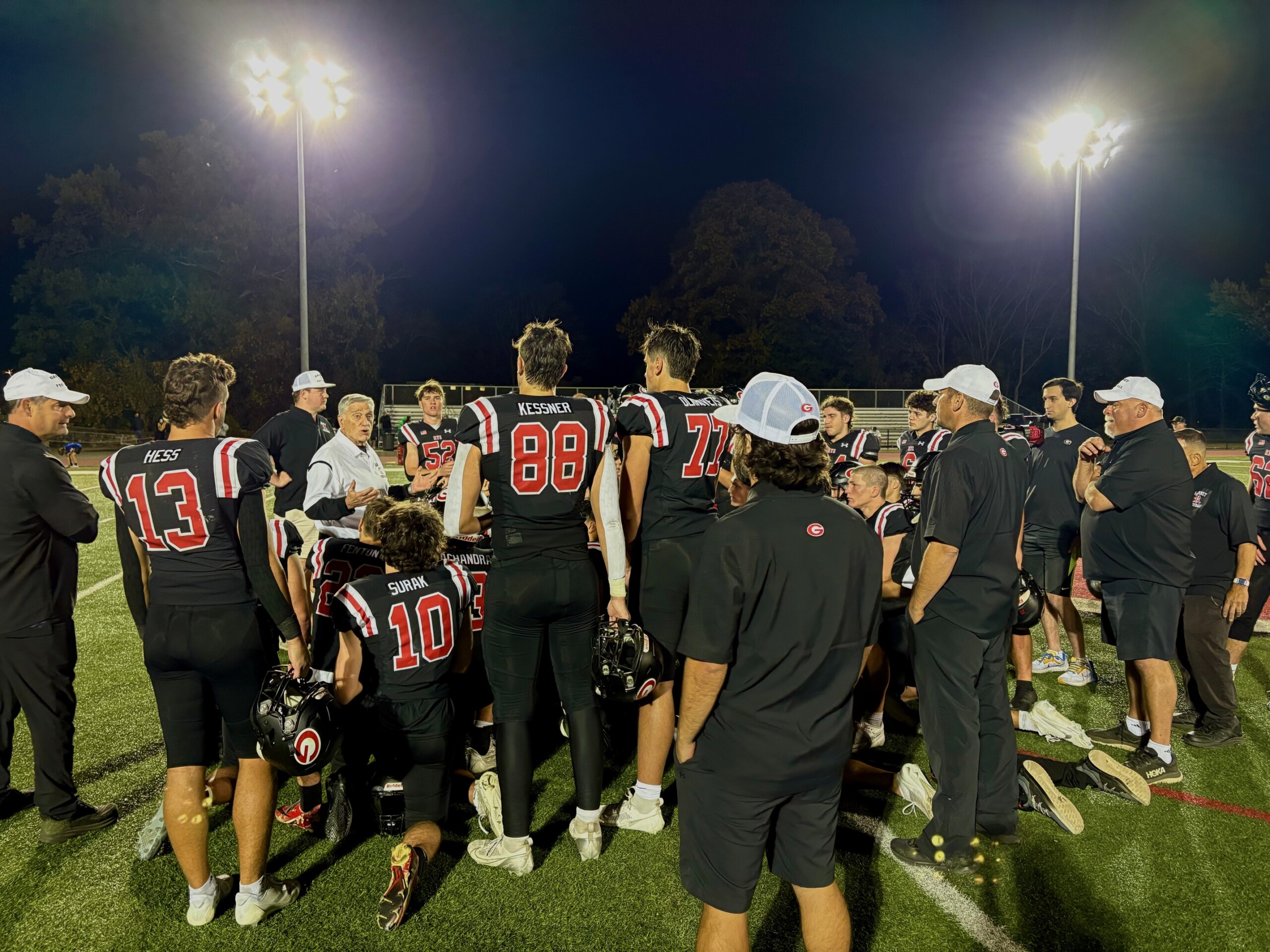 (PHOTO: Rye Football huddled around Head Coach Dino Garr after their quarterfinal win vs Brewster. Credit: Catherine Garr)