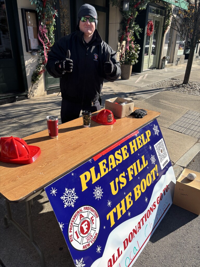 (PHOTO: Rye PD Local 2029 raised $8,472 during the union's annual boot drive on Saturday, December 7, 2024. Fire Fighter Andrew Wood works the donation table. Contributed: Local 2029.)