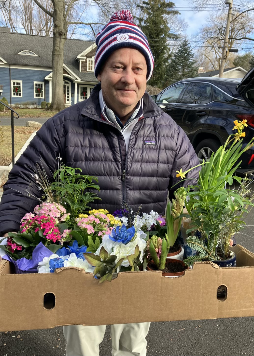 (PHOTO: Volunteer driver (and City Councilman) Bill Henderson from Meals on Wheels of Port Chester, Rye Brook and Rye prepares to deliver seasonal floral arrangements from local garden clubs in 2024. Contributed.)