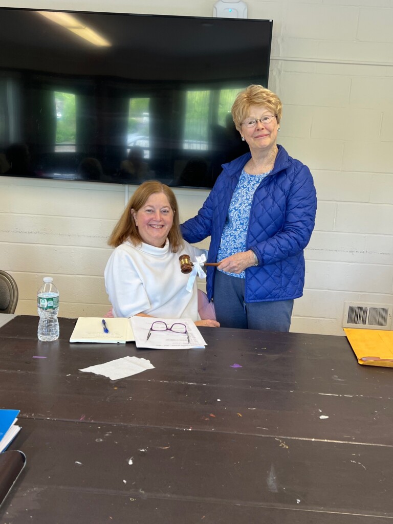 (PHOTO: Outgoing Co-President Eileen Shea handing over the gavel to President Debbie Berger at a The Woman's Club of Rye board meeting. Contributed.)