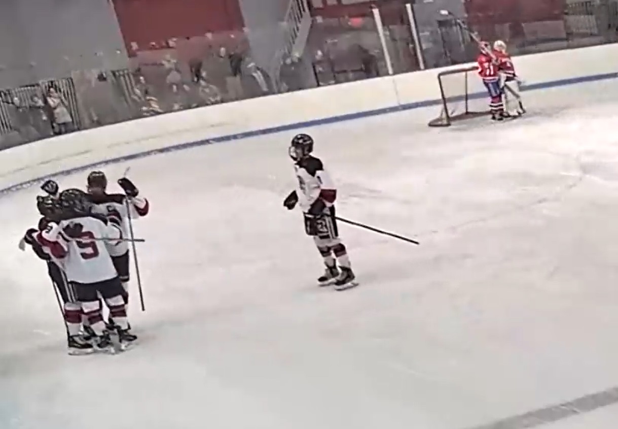 (PHOTO: Rye Varsity Hockey players surround Trevor Dolan after his go-ahead goal in the second period.)