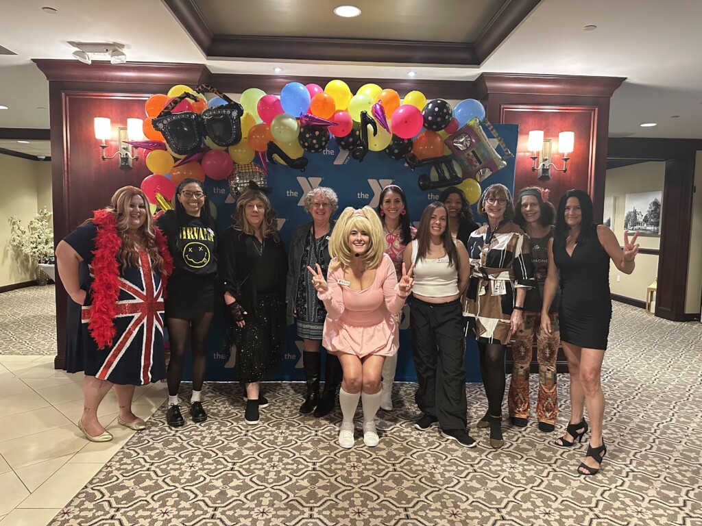 (PHOTO: At the Rye YMCA’s Dancing Through the Decades fundraiser on Friday, February 28, 2025, the Rye Y staff: Caitlin Bochicchio, Ana Cervantes, Barbara Hughes,  Denise Woodin, Heather Camacho, Liliana Gudino, Kathy Lynam, Traceann Rose, Susan Olson, Lisa Tidball, Melissa Lewis. Contributed.)