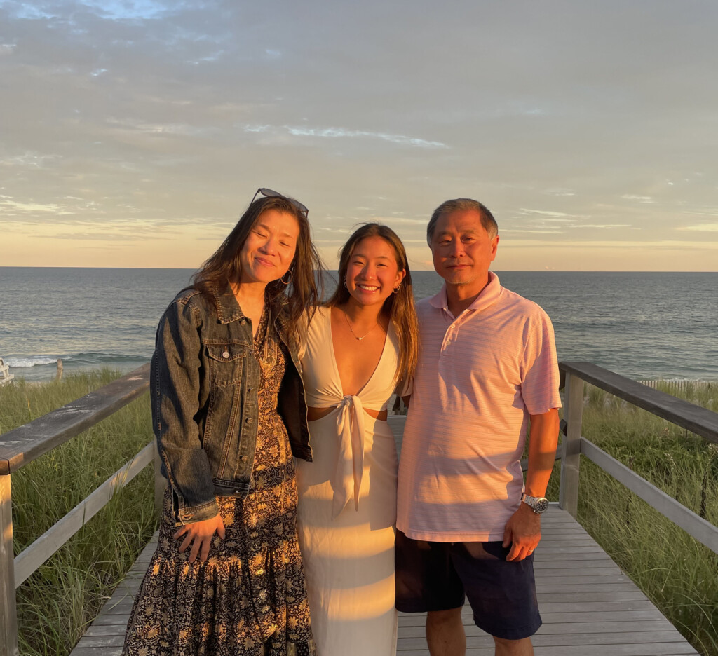 (PHOTO: Kaylie Nakamura (center, RHS '25) with her mom Eileen and her father Kuni on the beach in Quogue in 2022. Contributed.)