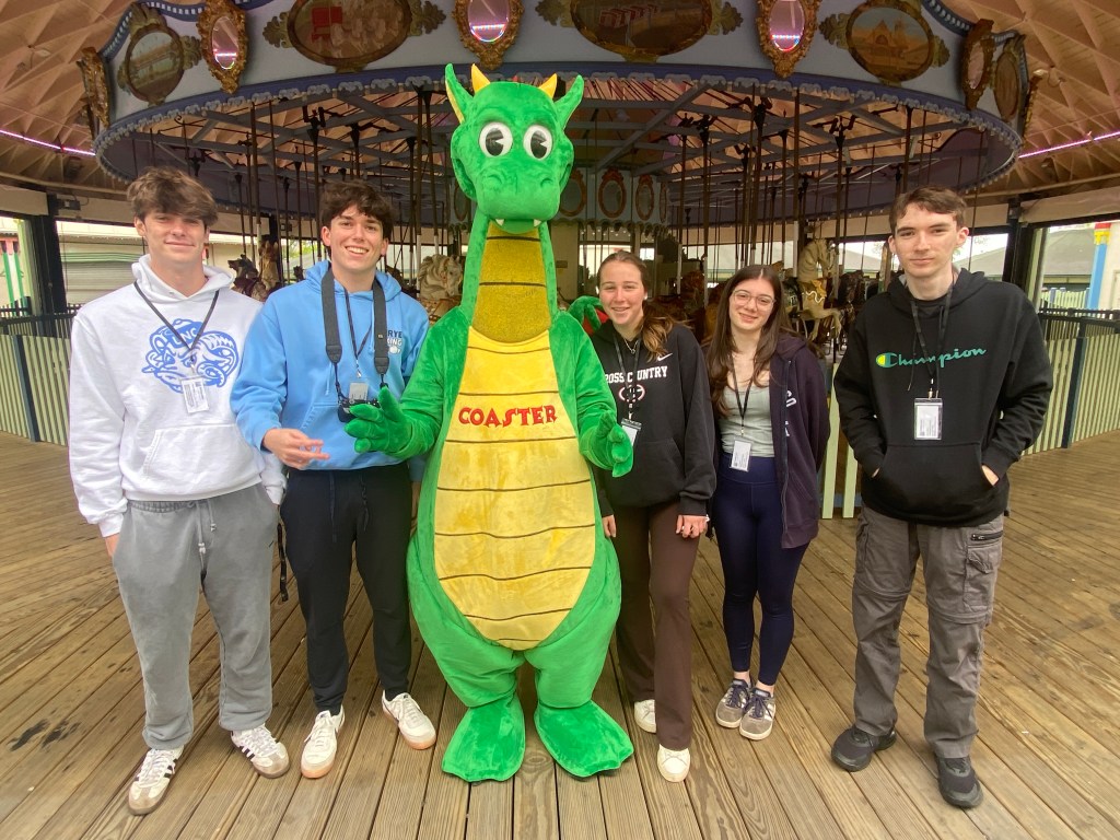 (PHOTO: MyRye.com interns from Rye High School with Coaster the Dragon during a Playland Park media walk-through on Friday, May 23, 2025.)
