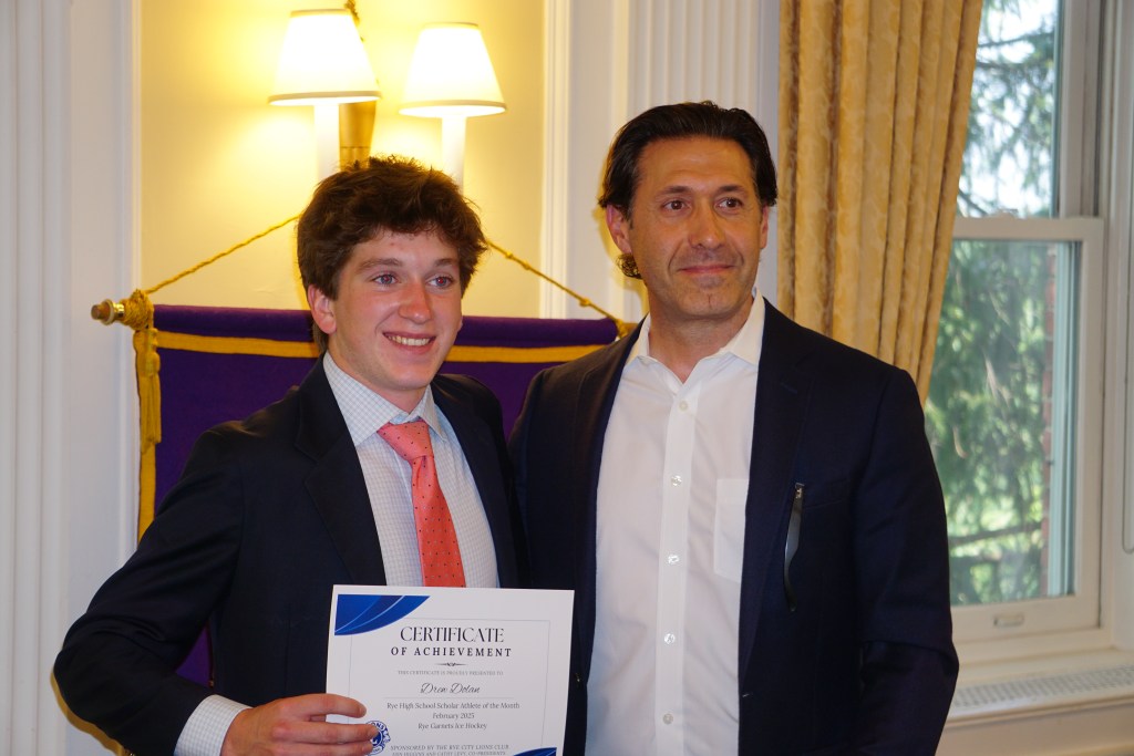 (PHOTO: Rye Varsity Boys Ice Hockey player Drew Dolan with Coach Peter Thomas at the Rye City Lions Club 27th Annual Scholar Athlete of the Year on June 12, 2025. Credit: Will Kressler.)