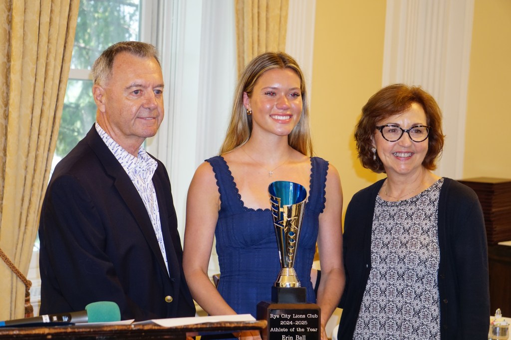 (PHOTO: Rye Varsity Track star Erin Ball was chosen by her classmates as the Rye City Lions Club 27th Annual Scholar Athlete of the Year. Left to right: Rye City Lion Tommy Maloney, Ball, Rye City Lions Co-President Ann Higgins. Credit: Will Kressler.)