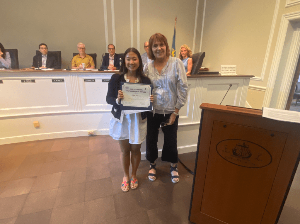 (PHOTO: Kaylie Nakamura with Rita Capek, head of Human Rights Commission, at the Rye City Council meeting on Wednesday, June 11, 2025.)