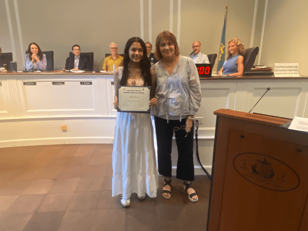 (PHOTO: Ashley Hernandez with Rita Capek, head of Human Rights Commission, at the Rye City Council meeting on Wednesday, June 11, 2025.)