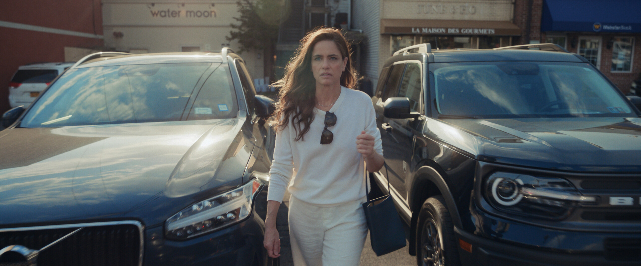 (PHOTO: A scene with Amanda Peet from “Your Friends & Neighbors” season 1, episode 2 filmed in Car Park 4 off Purchase Street. Water Moon restaurant and the June & Ho gourmet food store are viewable in the background. Source: Apple Studios.)