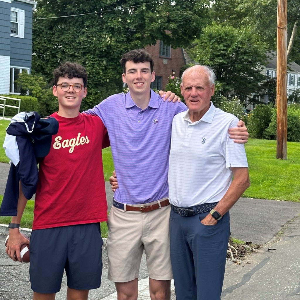(PHOTO: Mark Mulvoy with his grandsons Tommy Mangan (Boston College golf team) and Leo Mangan (Georgetown ‘25) outside their home in the Sunnyridge neighborhood of Harrison. Contributed.)
