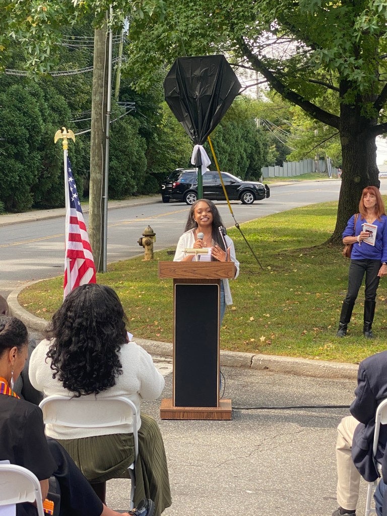 (PHOTO: The Paul & Orial Redd Way street naming at the Rye train station on September 27, 2025. Poet Laureate NAACP ACT-So Gold Medal Finalist Kaitlyn Leslie.)