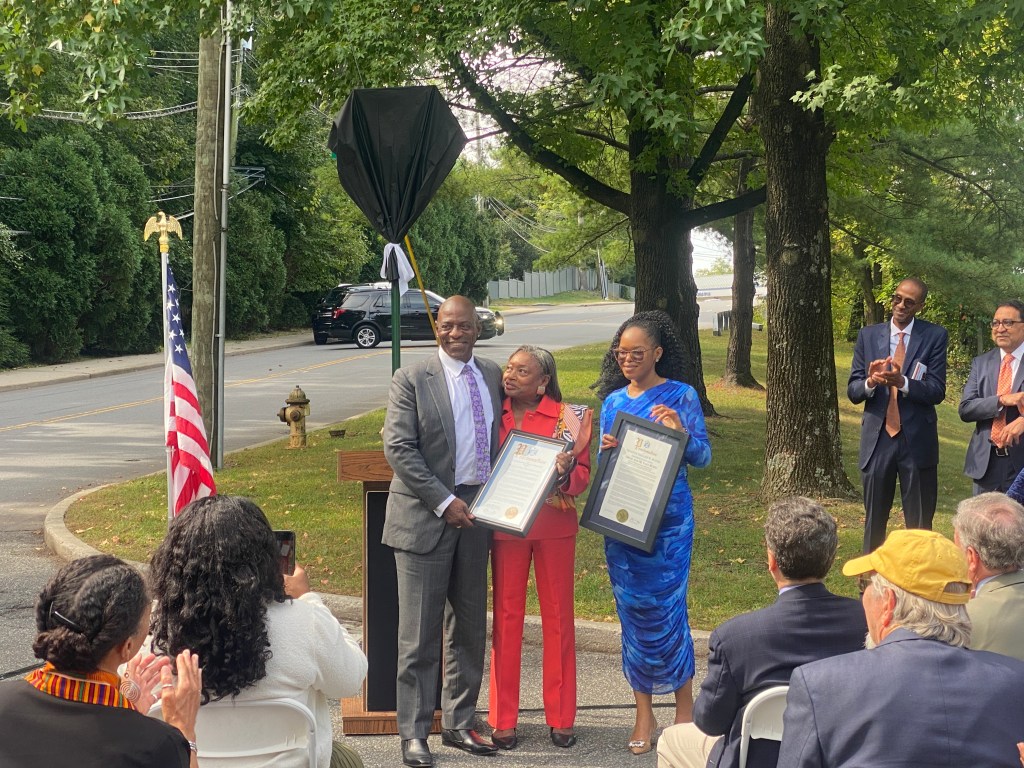 (PHOTO: The Paul & Orial Redd Way street naming at the Rye train station on September 27, 2025. New York State Senator Andrea Stewart-Cousins, president pro tempore and majority leader (in red) and a rep from State Senator Shelley Mayer's office presented proclamations.)