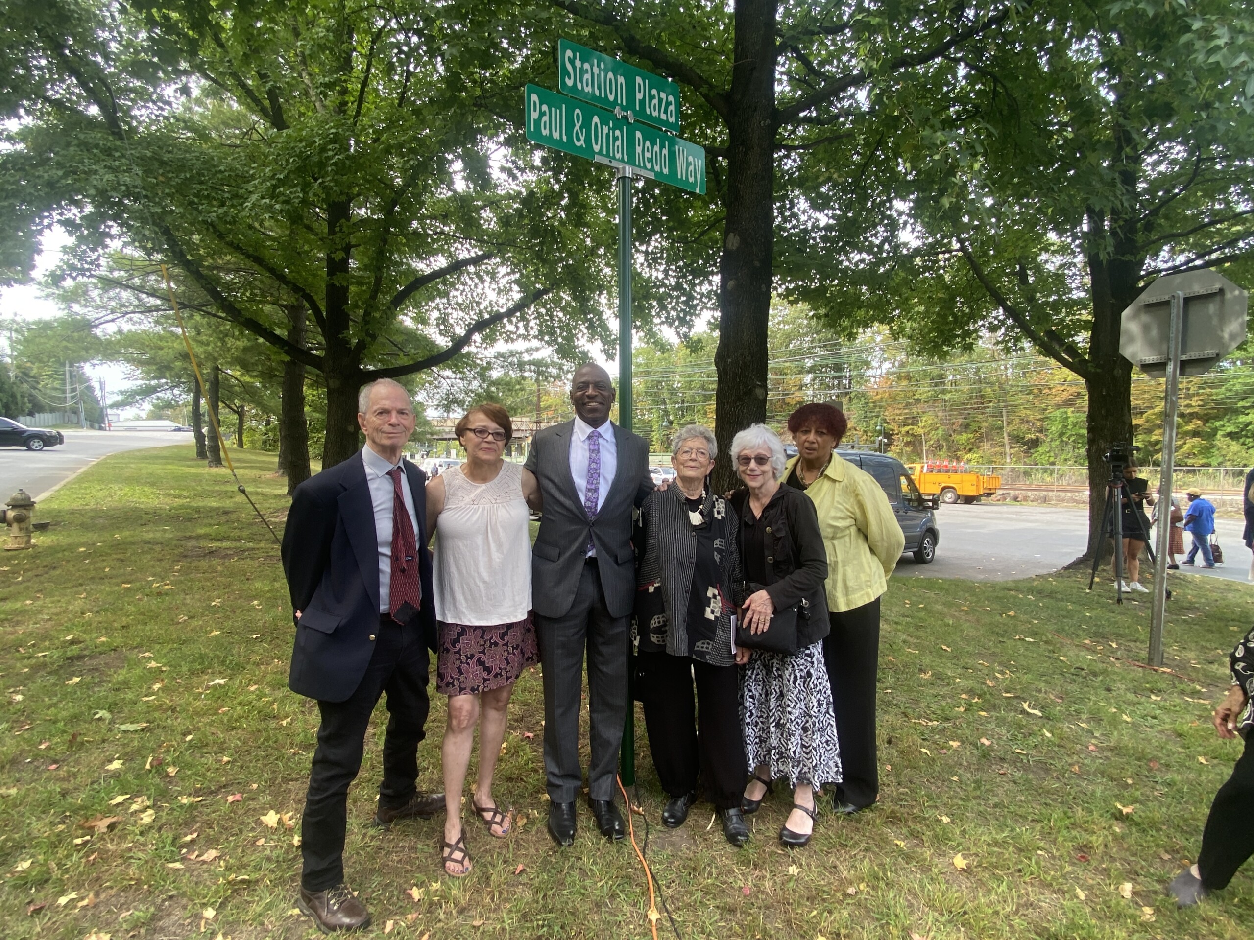 (PHOTO: The Paul & Orial Redd Way street naming at the Rye train station on September 27, 2025. Left to right: Peter Sterling (son of Dorothy Sterling), organizer and city council candidate Marion Anderson, Paul Redd Jr., Anne Fausto-Sterling (daughter of Dorothy Sterling), Karin Kunstler-Goldman (daughter of William Kunstler) and organizer Ingraham Taylor.)