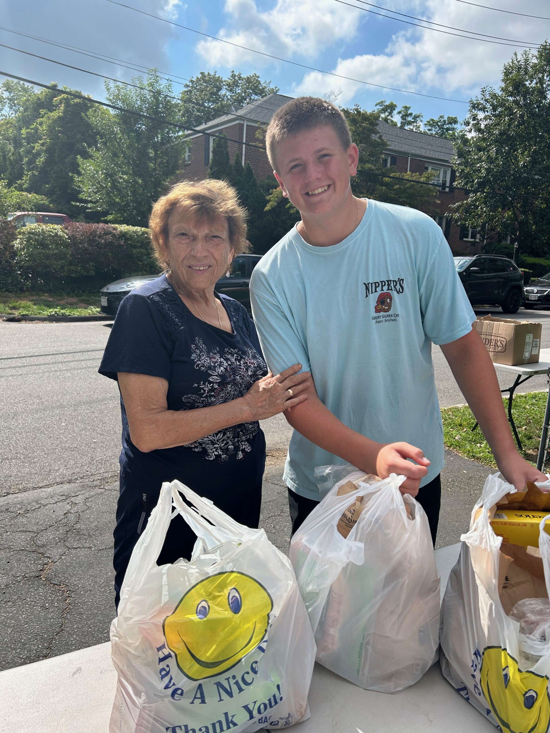 (PHOTO: A senior food recipient and Hayward Hodge, a student volunteer. Contributed.)