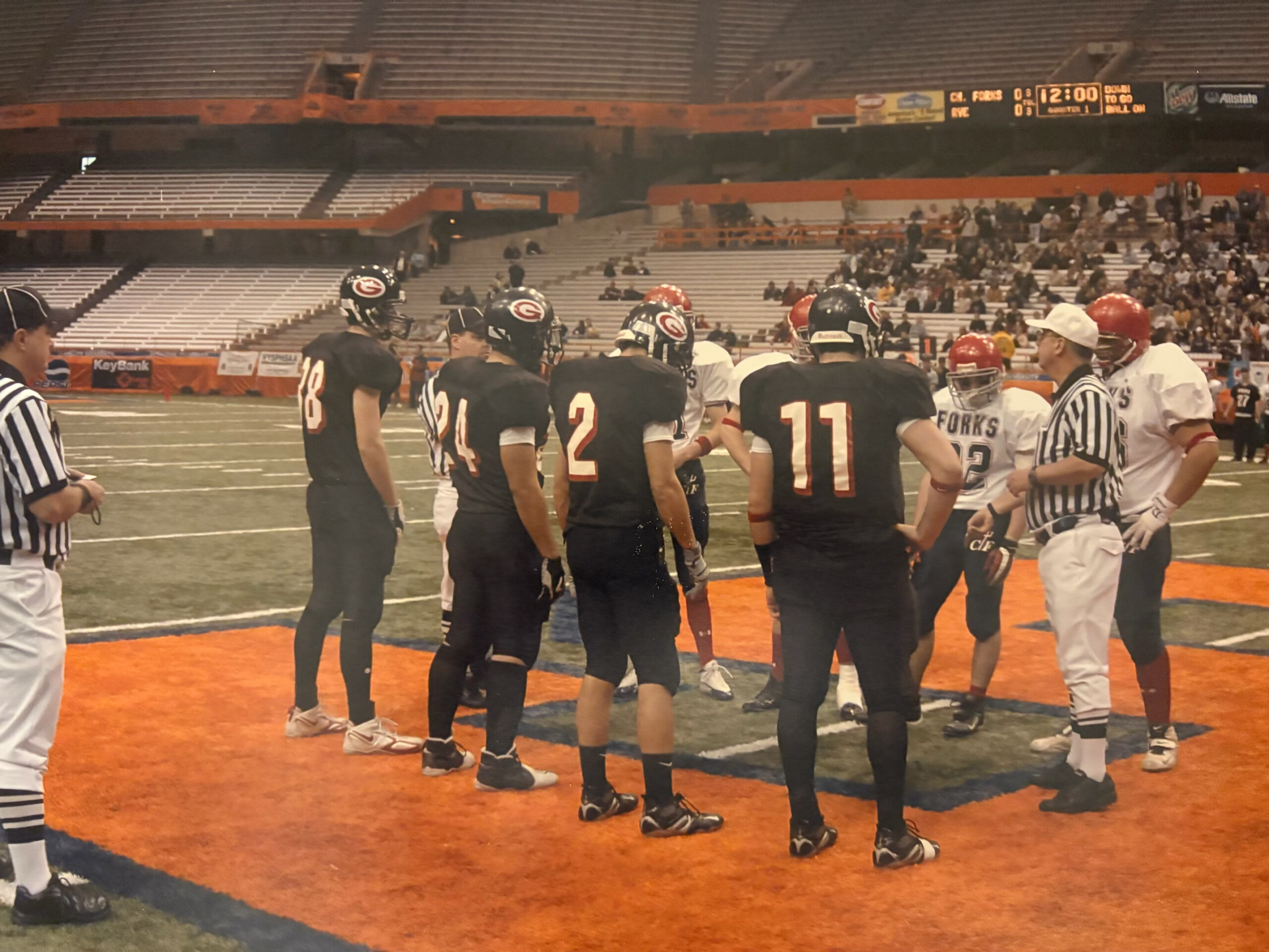 (PHOTO: 2005 Rye Football captains Tim Monaghan, Rob Nieves, Peter Niehaus, and Peter Longo taking the coin toss at the Carrier Dome in the state championship game. Contributed.)