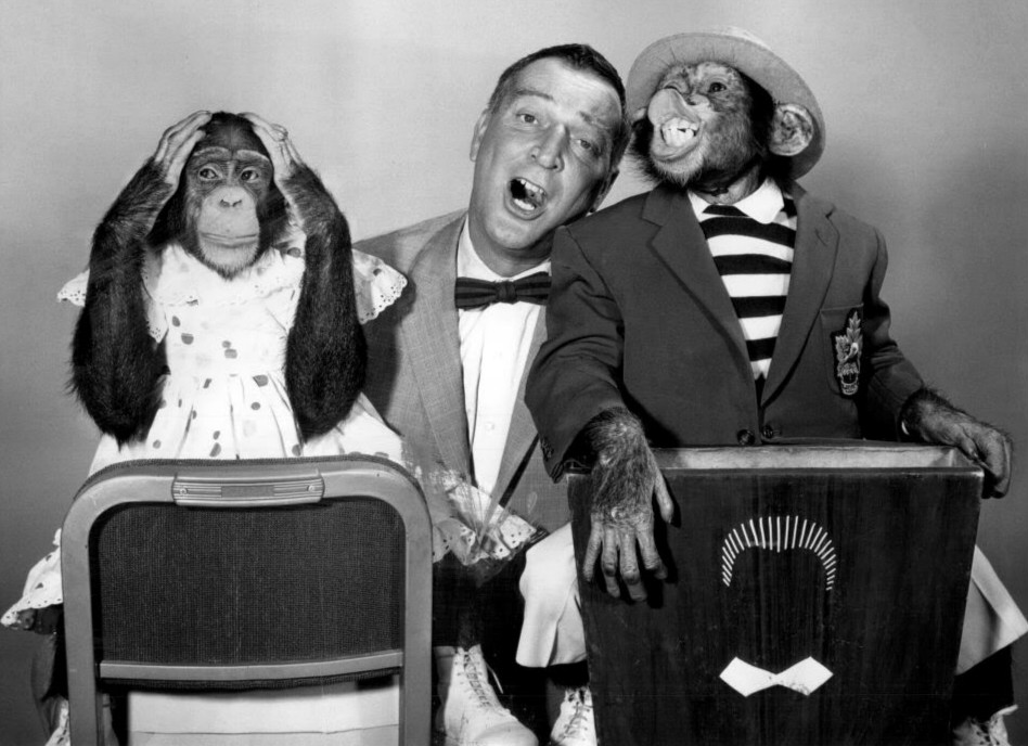 (PHOTO: Publicity photo of Garry Moore with his guests, the Marquis Chimps, from The Garry Moore Show. October 1959. Public Domain.)