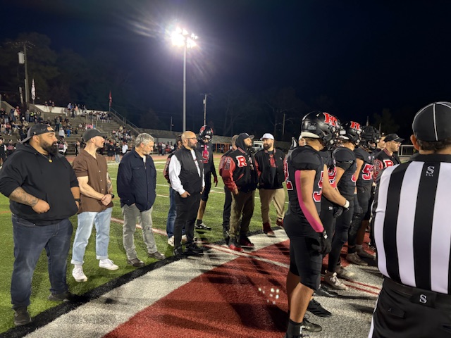 (PHOTO: The 2025 Rye Football captains are joined by the 2005 Rye Football captains for the coin toss on October 17, 2025. Contributed.)
