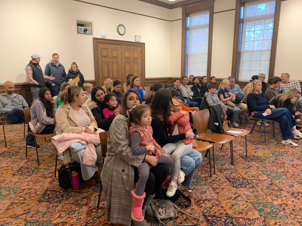 (PHOTO: The assembled crowd at the Eighth Annual Rye Free Reading Room Spelling Bee with Rye Mayor Josh Cohn and Rye Free Reading Room Library Director Chris Shoemaker on November 11, 2025. Contributed.)