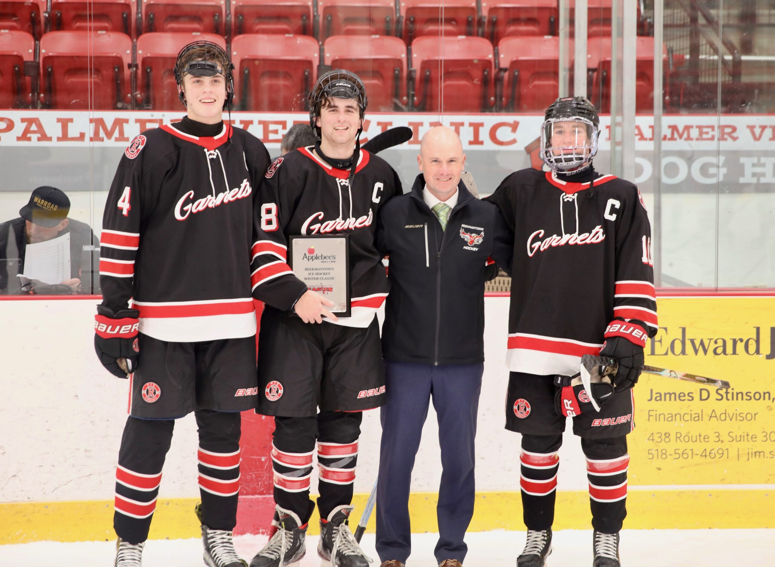 (PHOTO: The 2025 Rye Hockey captains with the 2025 Applebee's Winter Classic championship trophy on December 20, 2025. Garnets L to R: Will Weinman, Ryan Draddy, Trevor Dolan. Contributed.)