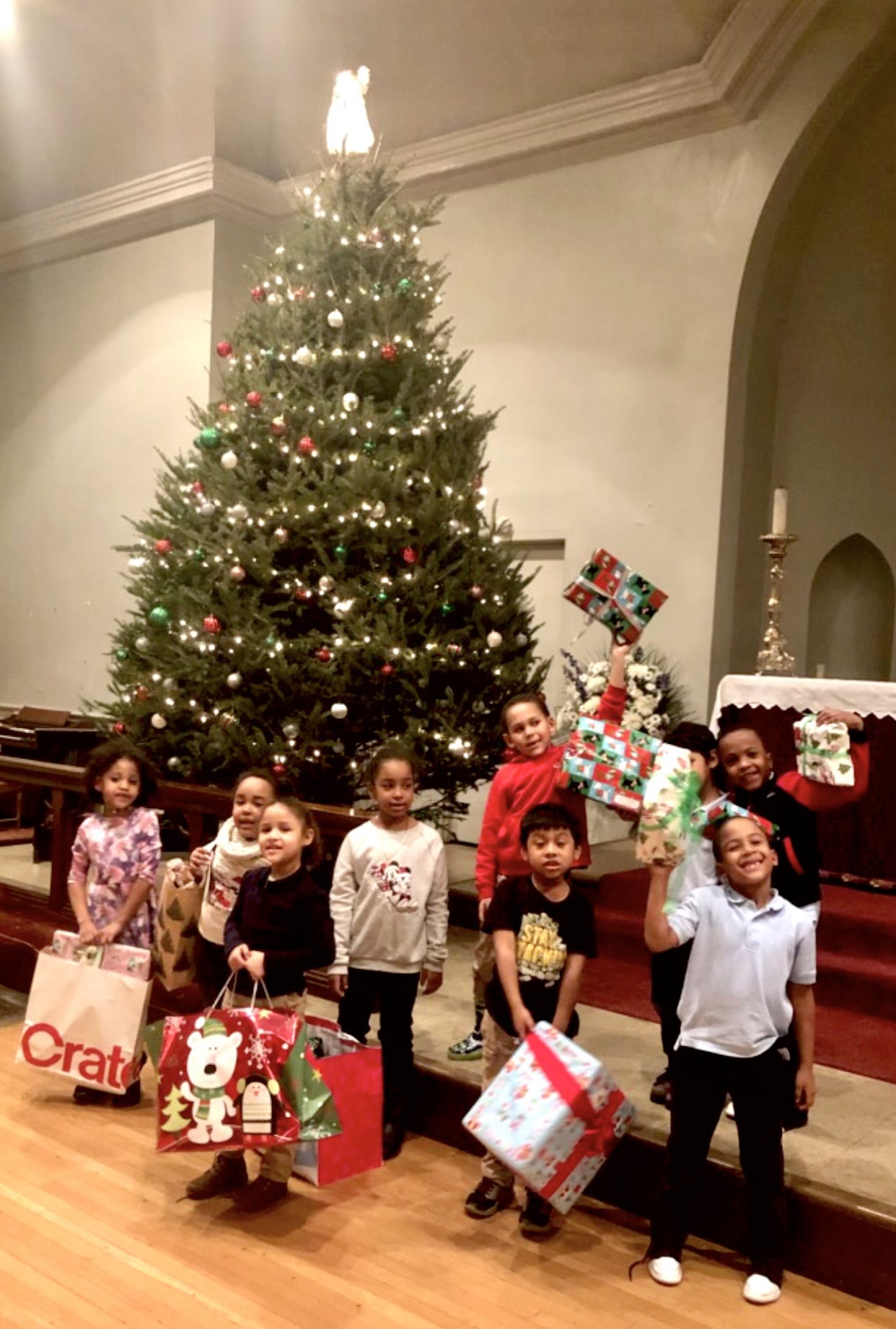 (PHOTO: Children receiving gifts from The Children’s Collective’s Holiday Angel drive. Contributed.)