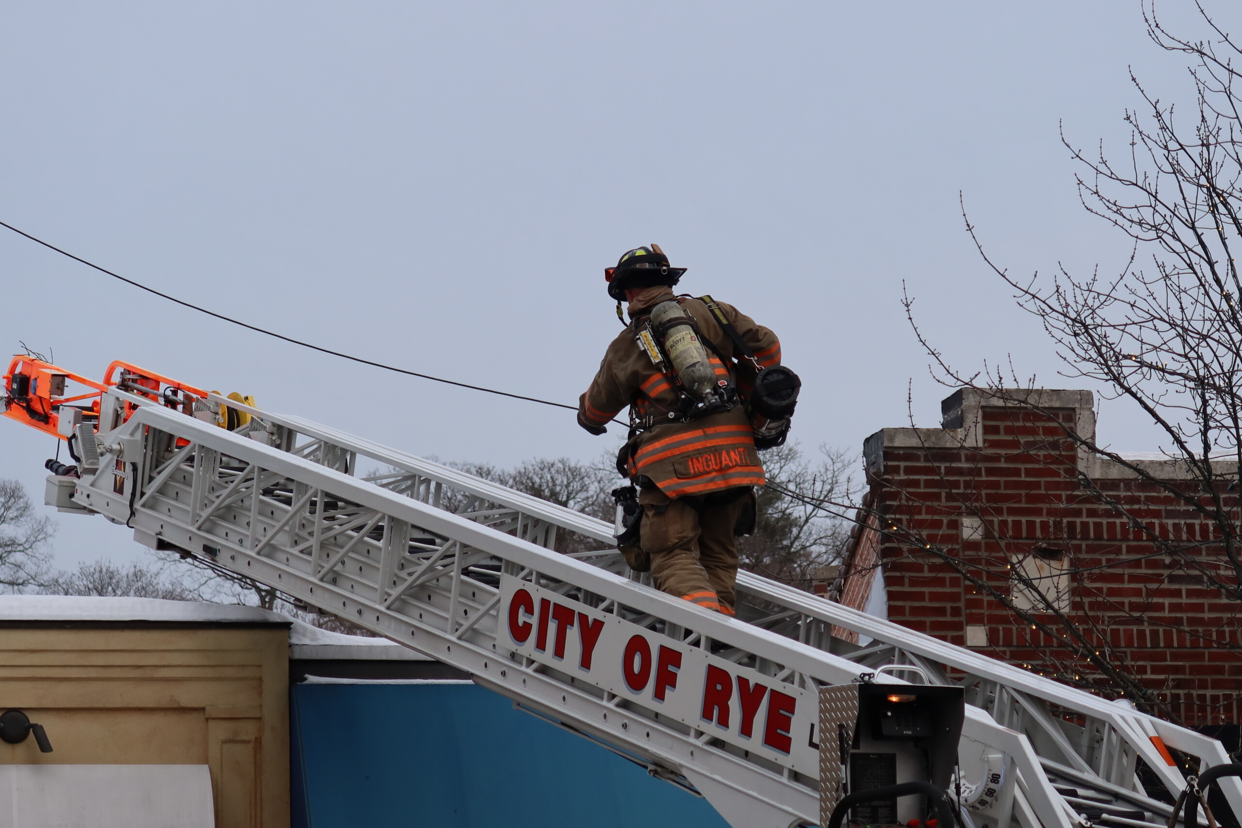 (PHOTO: Rye FD Firefighter Sal Inguanti, climbs the aerial ladder to access the roof of Aurora Restaurant in downtown Rye at 60 Purchase Street on Wednesday afternoon, January 28, 2026. Source: Rye FD.)