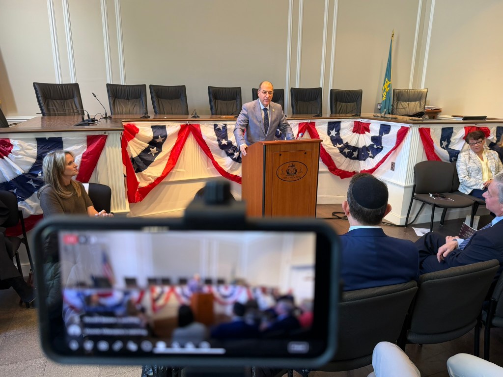 (PHOTO: The City of Rye inauguration ceremony on January 4, 2026. Newly elected Rye Mayor Josh Nathan addresses the room and the live MyRye.com broadcast of the inauguration.)