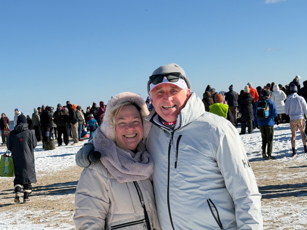 (PHOTO: 203 people participated in the 26th annual Polar Plunge at Oakland Beach in Rye on Thursday, January 1, 2026. The event money for local charities Soul Ryeders and Meals on Main Street. Citizen and newly former County Legislator with Ken Harris, co-president of the Rye Tri Club and event emcee. Contributed.)