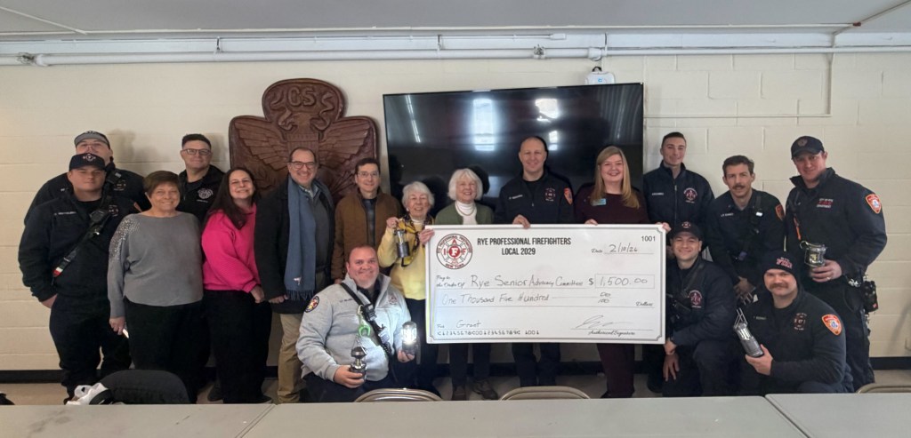 (PHOTO: 2029 Fundraising, the nonprofit arm of the Local 2029 Rye Professional Firefighters union, presented a check for $1,500 to the Rye Senior Advocacy Committee on Tuesday, February 10, 2026 that will fund the purchase of 260 emergency lanterns that seniors can use during power outages.)