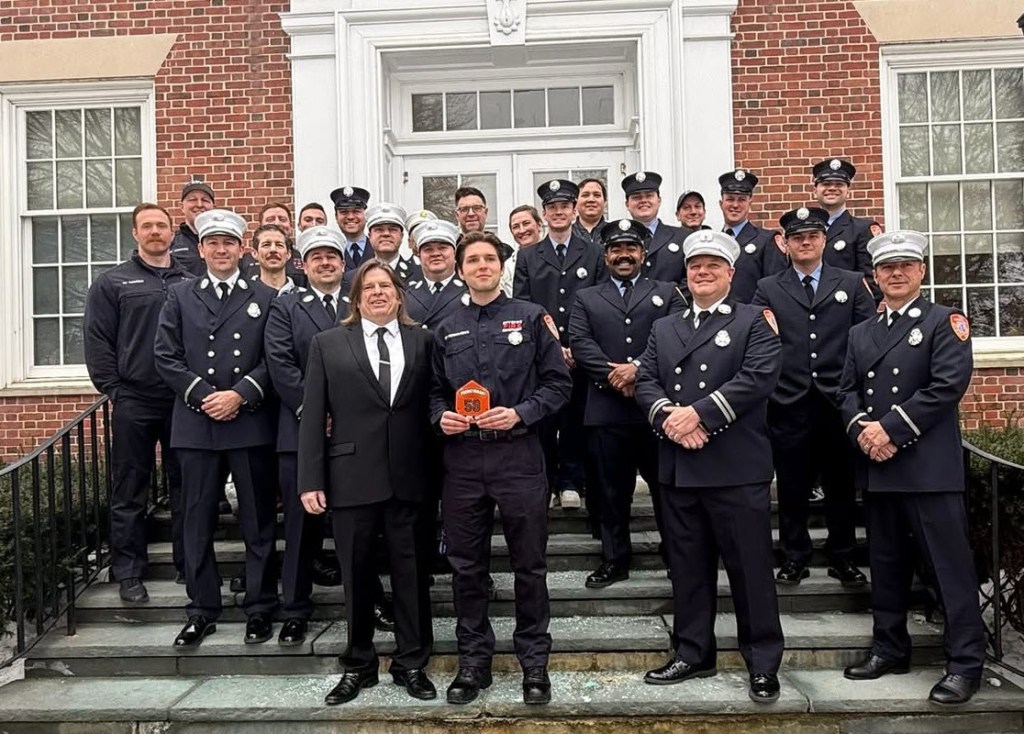 (PHOTO: Rye Fire Department employees at Rye City Hall on Tuesday, February 17, 2026 for the swearing in of probationary firefighter Jeffrey Fernandes. In the front is Fernandes (holding badge) and his father Jeffrey Fernandes (senior) to the left. Contributed.)