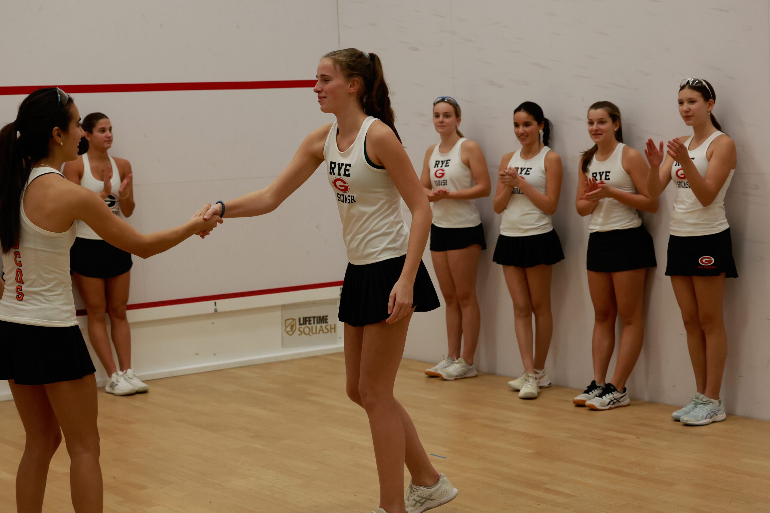 (PHOTO: Rye Girls Squash's Natalie Hofmann shaking hands with her opponent from Greenwich Country Day School from the 2026 season. Contributed.)