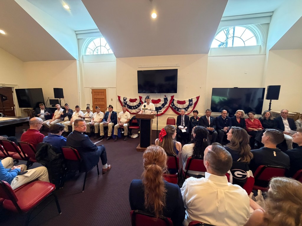 Large crowd at Memorial Day Ceremony inside Firehouse.