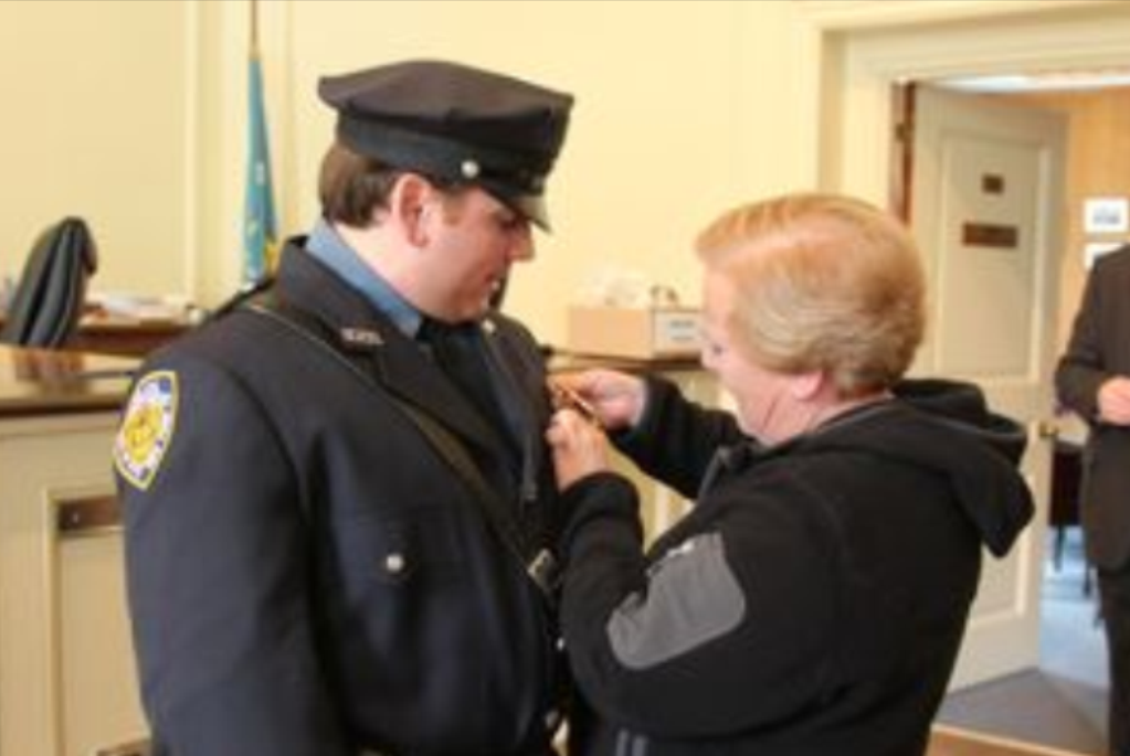 (PHOTO: Michael Anfuso receiving his sergeant’s badge in 2012. The badge is being pinned by Anfuso's aunt Gail Klepps, who served as secretary to the chief and commissioner from 1975 to 2014. Contributed.)