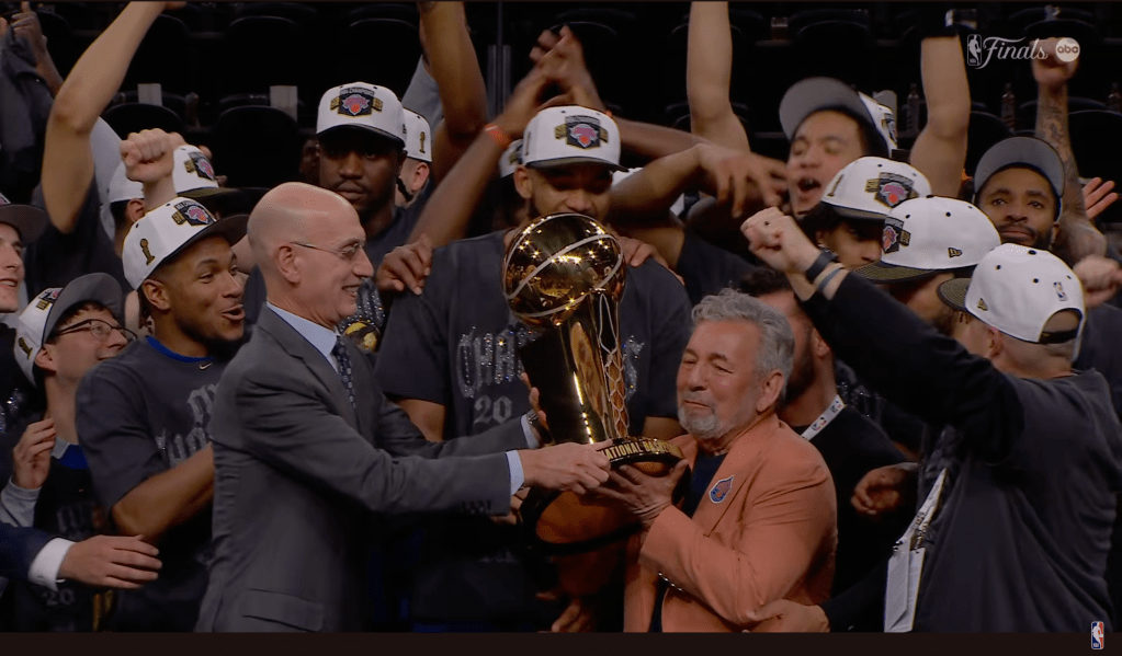 (PHOTO: Adam Silver handing over the Larry O'Brien Championship Trophy to Knicks Executive Chairman and CEO James Dolan. Source: ABC TV - NBA via YouTube.)