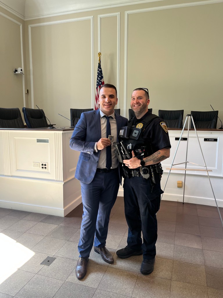 (PHOTO: Officer Dashi (left) with Patrol Commander Lt. Al Hein (right) at Officer Dashi's swearing in ceremony at City Hall on July 10, 2026. Contributed.)
