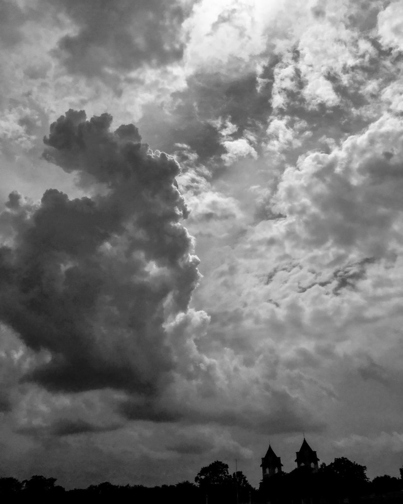(PHOTO: Cloud Formations. Light breaks through shifting clouds towering over the Playland Boardwalk. By Markus Peters.)