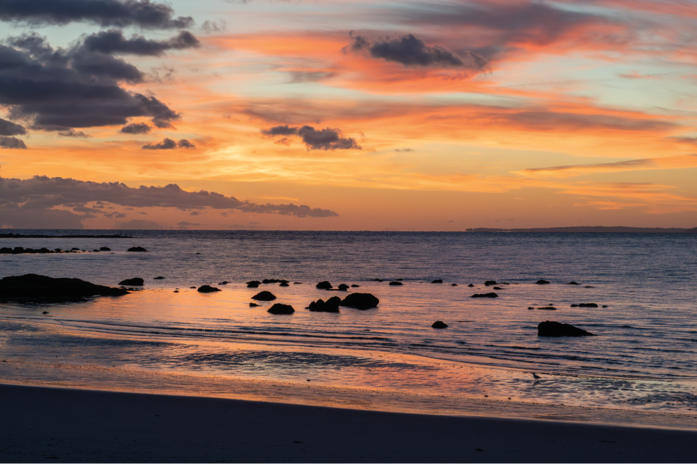 (PHOTO: Layered Hues. Sunrise drifts across the sky and shore. By Stacey Massey, author of First Light, Rye.)
