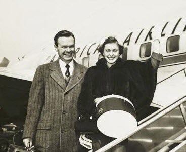 Husband and wife in front of an airplane