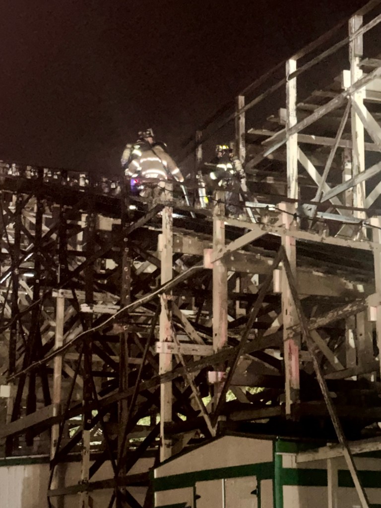 Firefighters climbing roller coaster structure