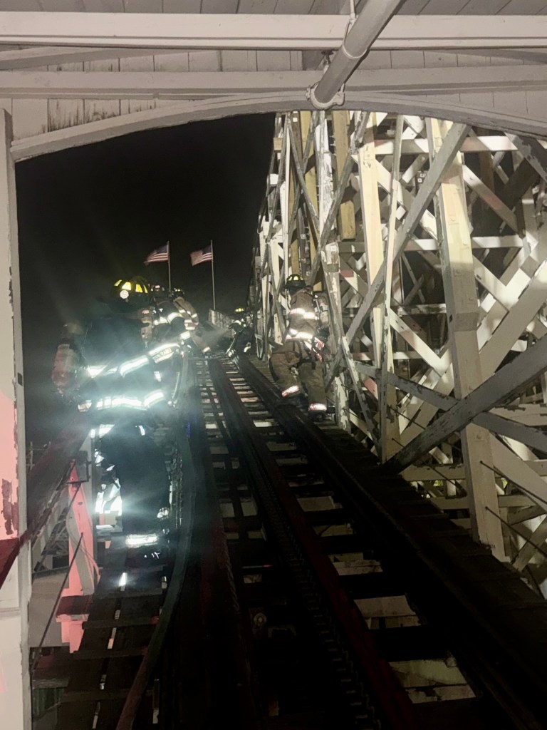 Firefighters climbing roller coaster structure